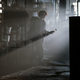 Mckenna Grace's Phoebe stands in a splash of sunlight in a very dark room in Ghostbusters: Afterlife. She's got a proton pack on her back and wand in hand.